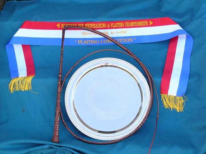 P1090372-1.jpg - 32 x 24 plait Australian stock whip placed first at the 2004 "Australian Plaiting Championships" at Glen Innes. Shown here with the ribbon and the "Doohan McMaster Perpetual Trophy" .