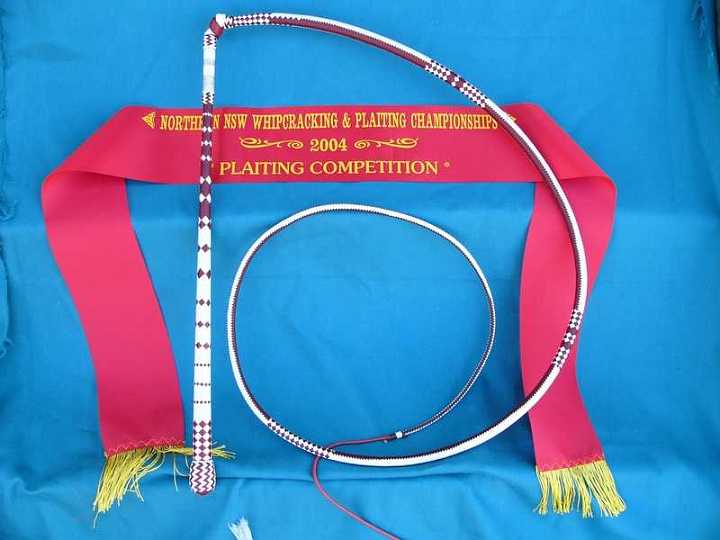 P1090382-1.jpg - 24 x 24  plait 6ft Australian stockwhip  Red and White Kangaroo hide .With simple pattern changes in the handle and the thong.
placed 2nd at the 2004 "Australian Plaiting Championships".